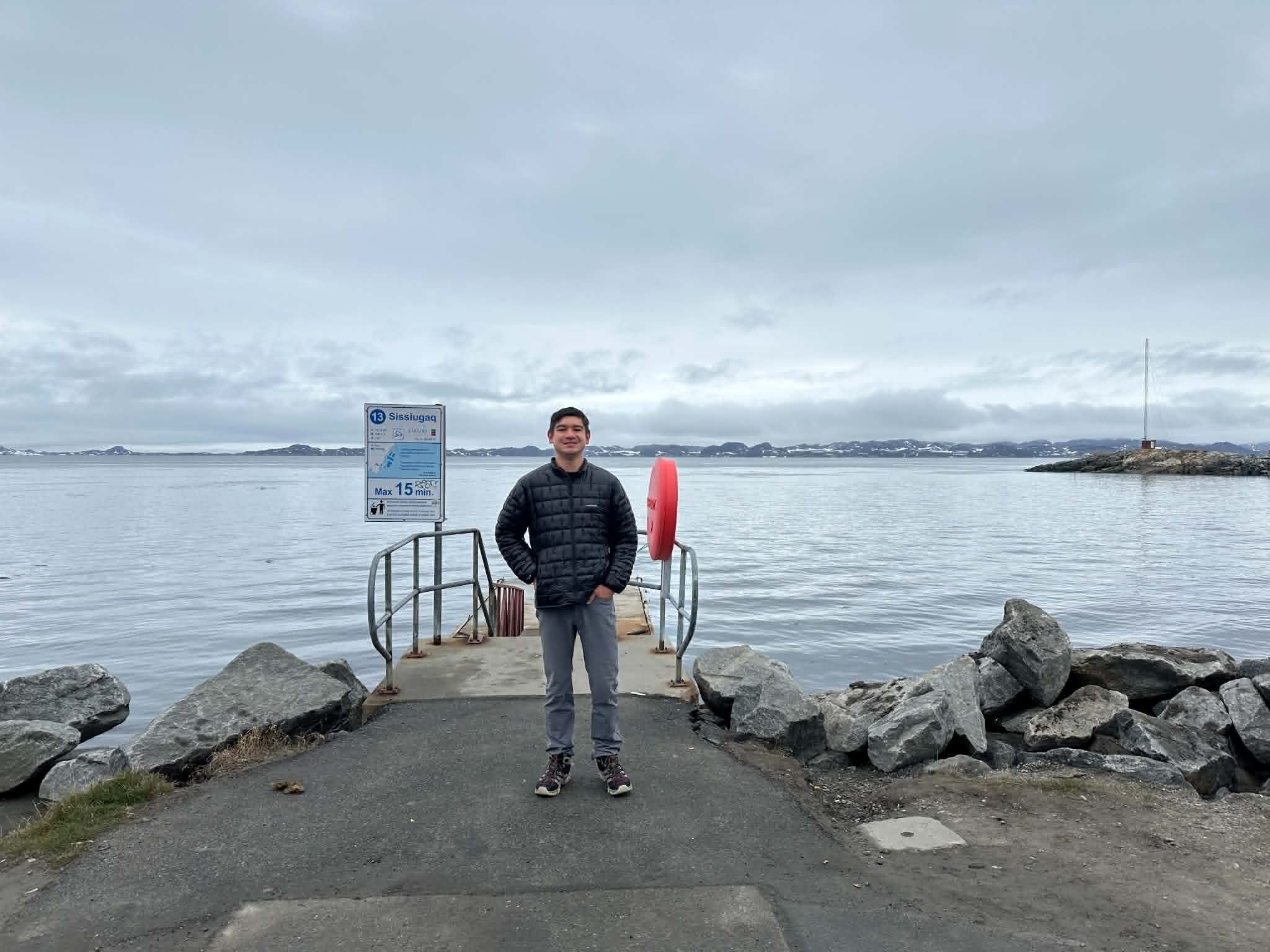 Standing at a small public dock in Nuuk with mountains and sea behind