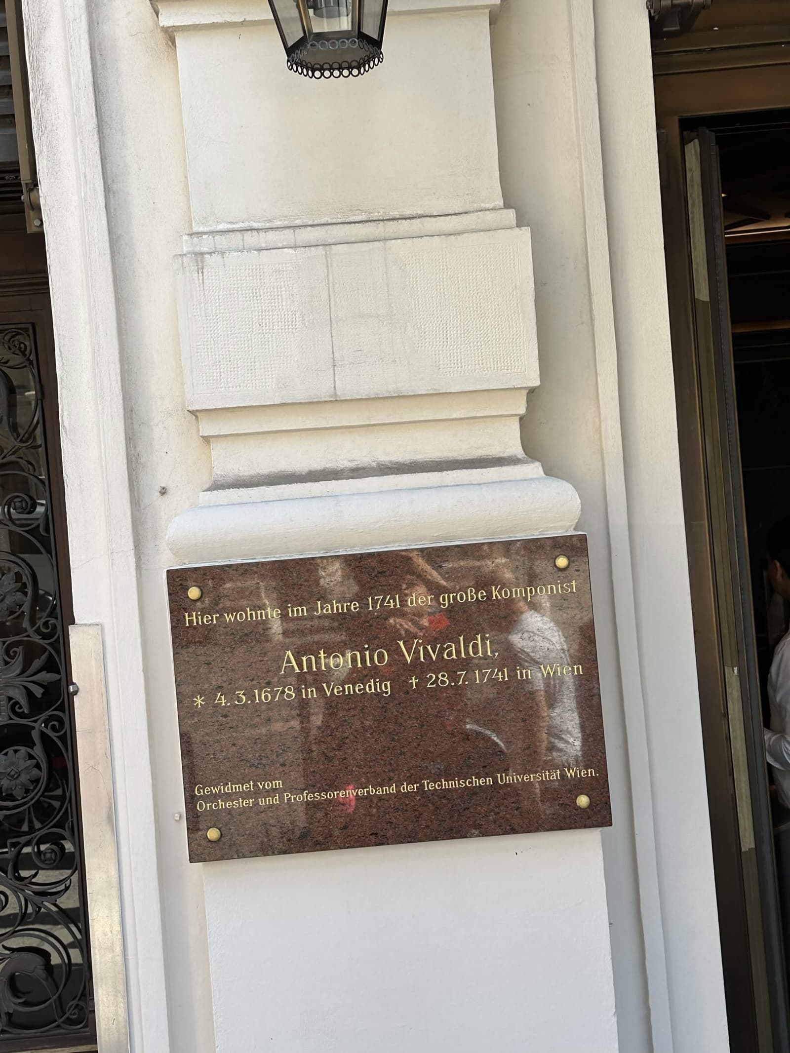 A dark stone plaque on a white wall reading that the great composer Antonio Vivaldi lived here in 1741, born 1678 in Venice and died 28 July 1741 in Vienna
